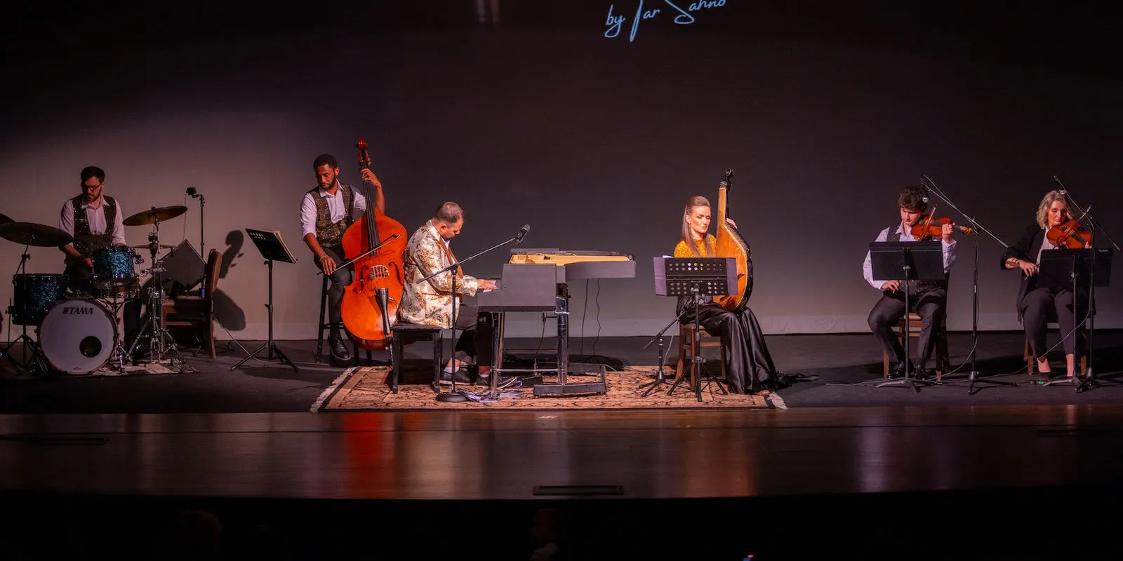 The full ensemble on stage: drums, double bass, piano, bandura, and two violins